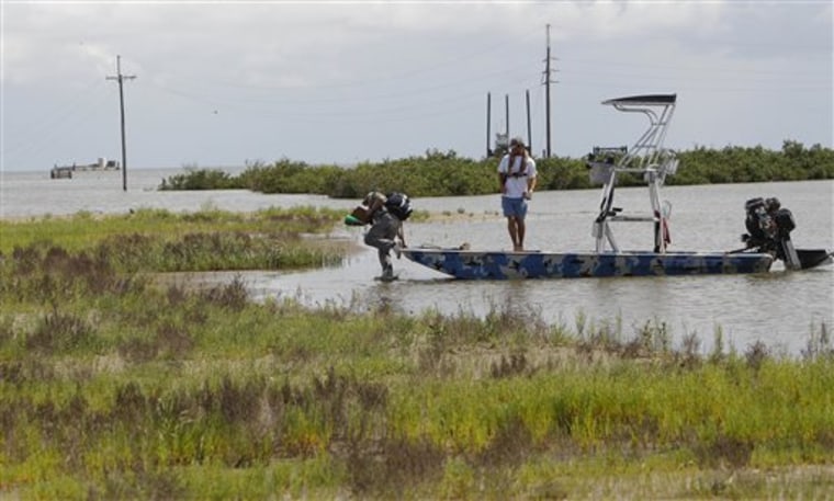SCAT team leader Ivor van Heerdenon, left, climbs off a boat on East Timbalier Island, La., Wednesday. Heerdenon is part of a Shoreline Cleanup and Assessment Team surveying the shorelines along the Louisiana coast for oil impact from the Deepwater Horizon incident. 